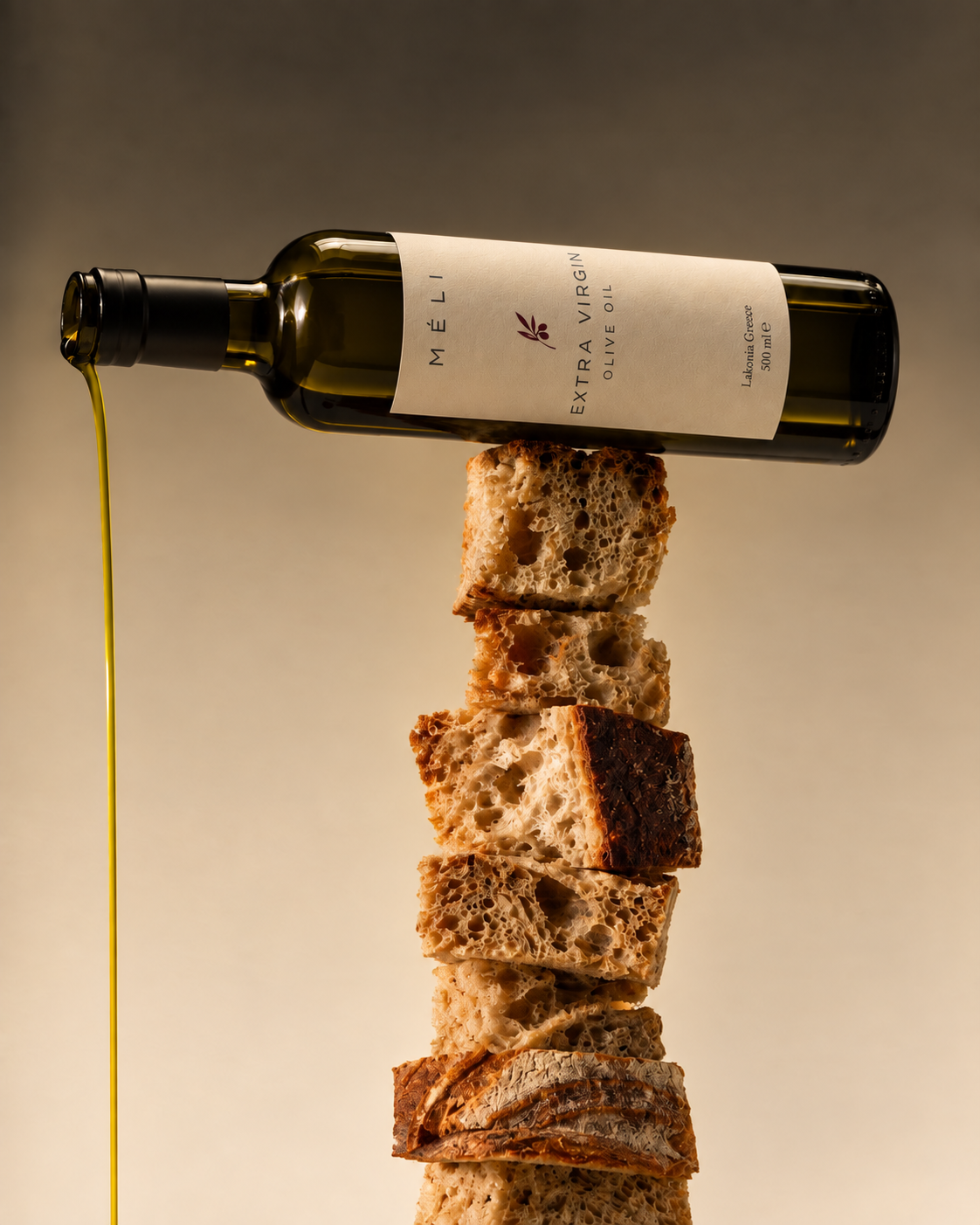 MÉLI olive oil bottle balanced over artisan bread